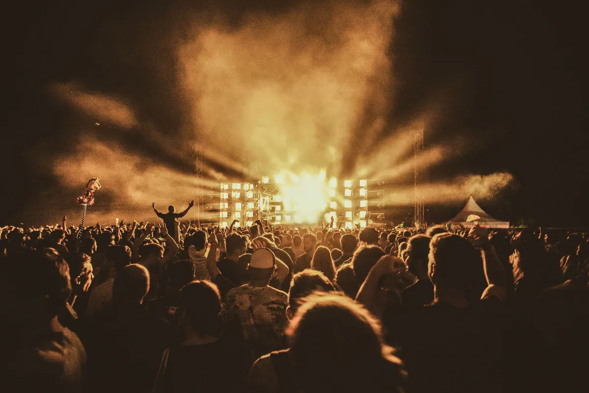 Concert crowd under stage lights at an outdoor venue