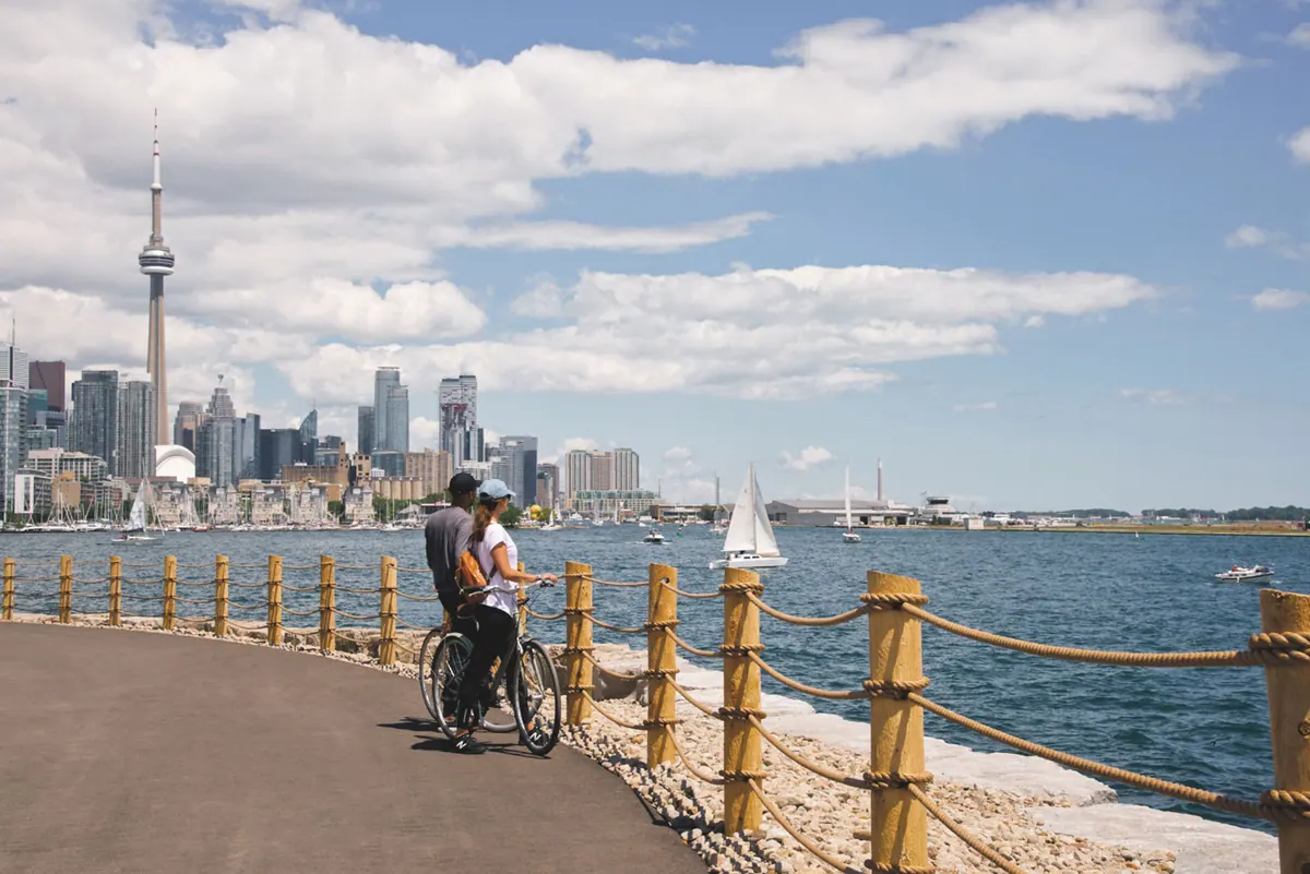Cyclists on the waterfront trail with the downtown skyline